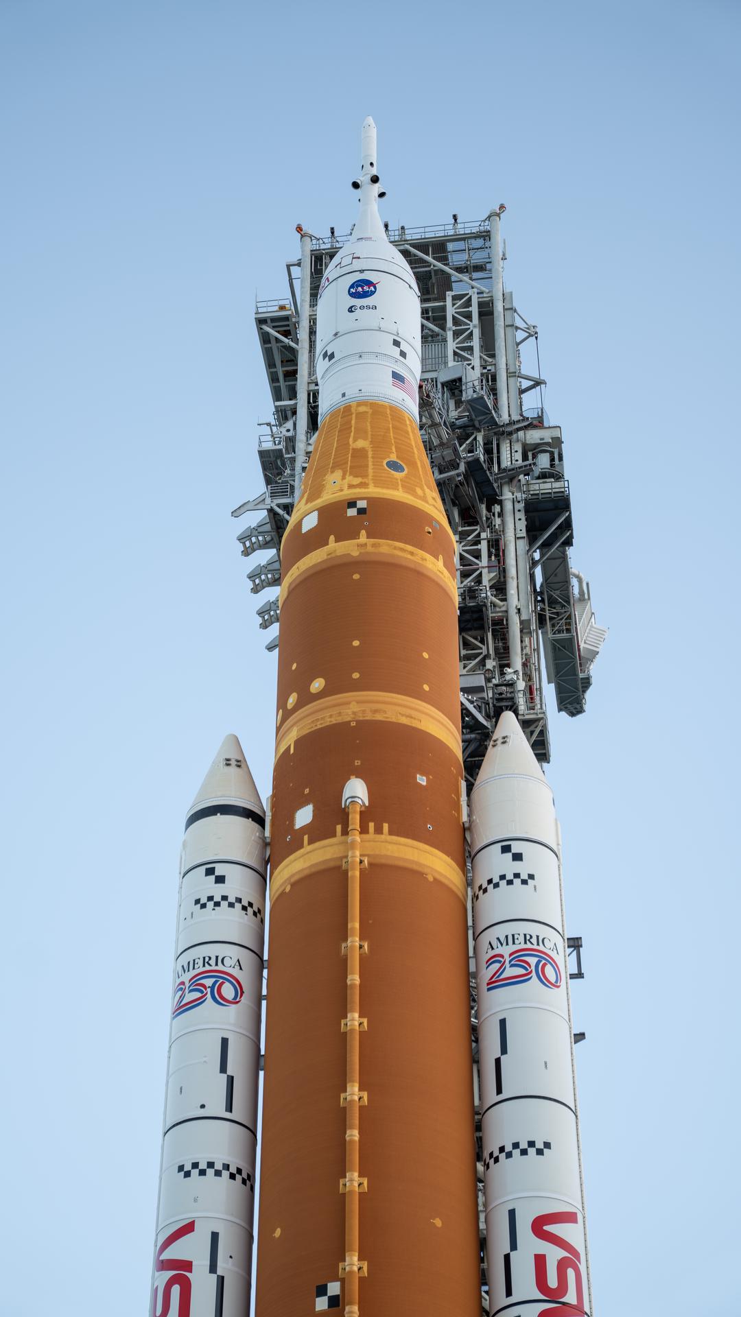 This image shows NASA’s SLS (Space Launch System) and Orion spacecraft rolling out of the Vehicle Assembly Building at NASA’s Kennedy Space Center. NASA's massive Crawler-Transporter, upgraded for the Artemis program, carries the powerful SLS rocket and Orion spacecraft on the Mobile Launcher from the Vehicle Assembly Building to Launch Pad 39B at Kennedy Space Center in preparation for the Artemis II mission. 